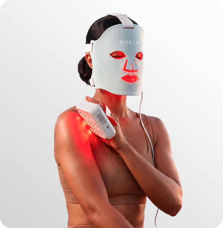 A woman wearing a white KALA red light therapy face mask and a matching red light therapy shoulder device, with the devices glowing red, against a clean white background.