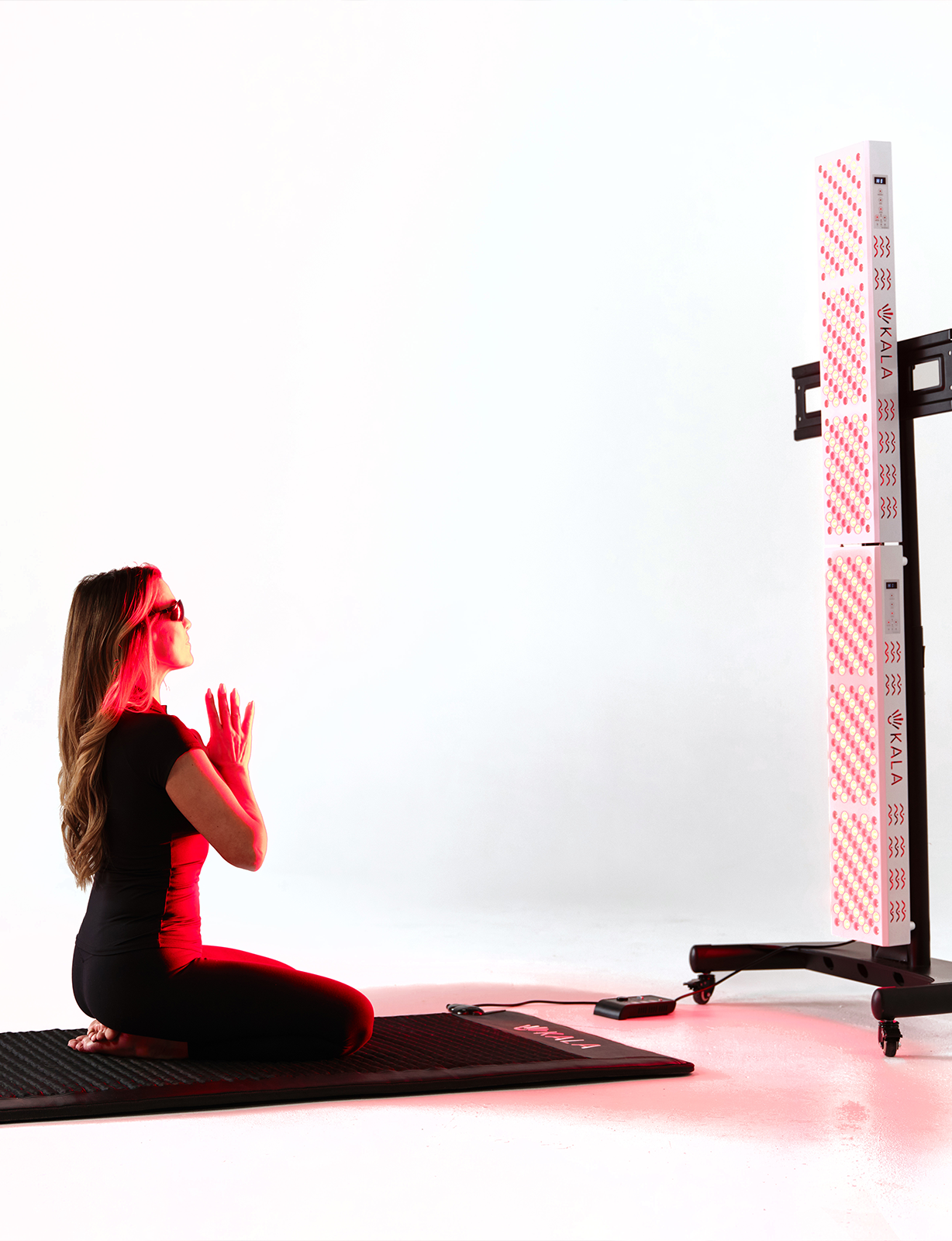 Person practicing yoga with kala red light therapy.