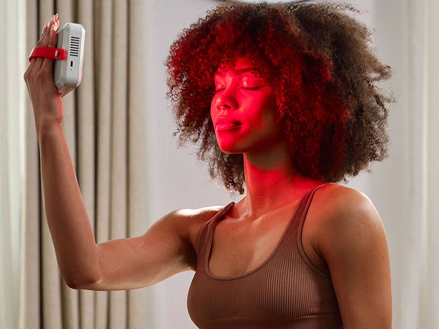 Woman taking a selfie in a room with kala red Light mini 2.0 delivers medical-grade red and near-infrared therapy in a compact, travel-ready design.