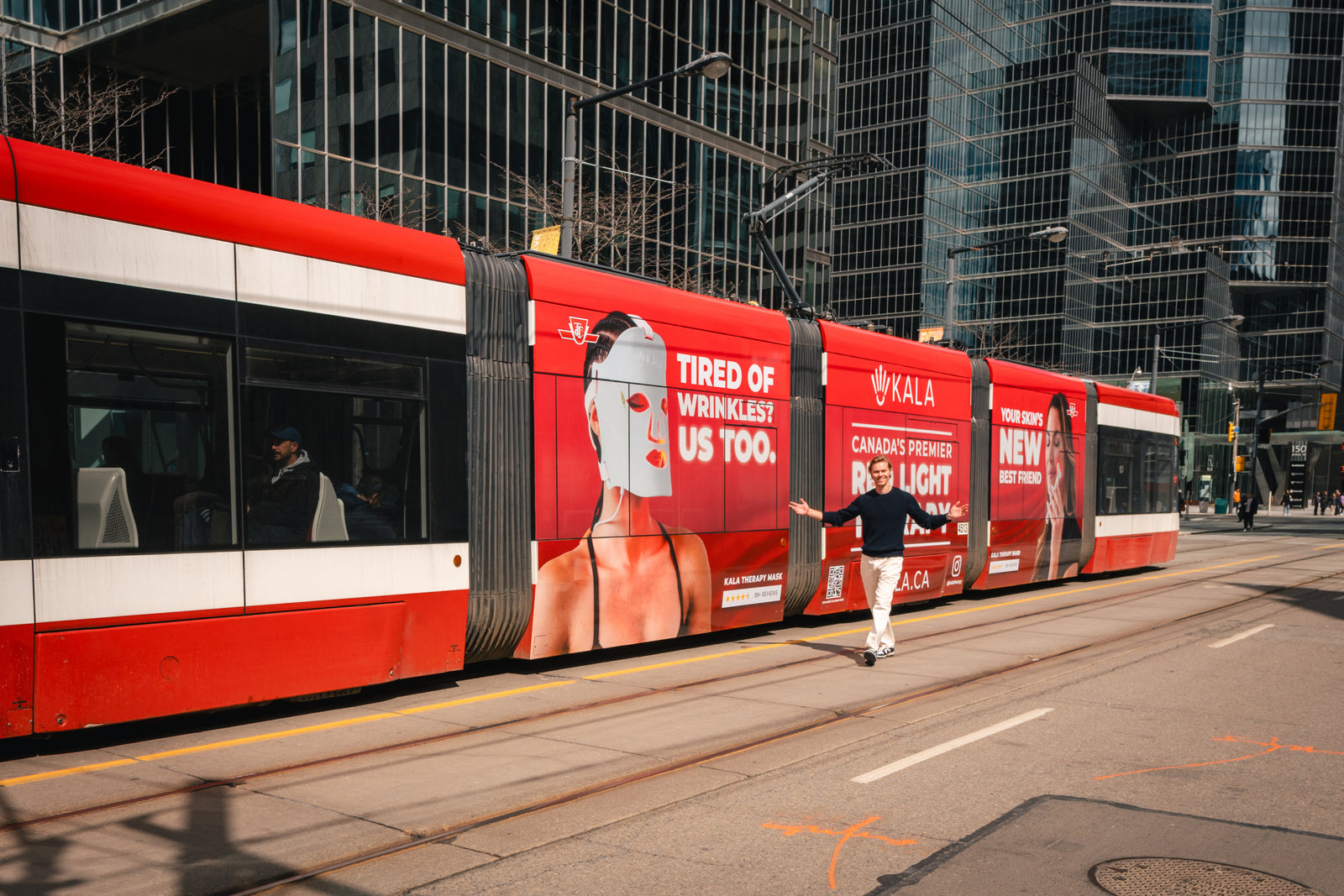 Red and white tram with advertising on a kala red light brand