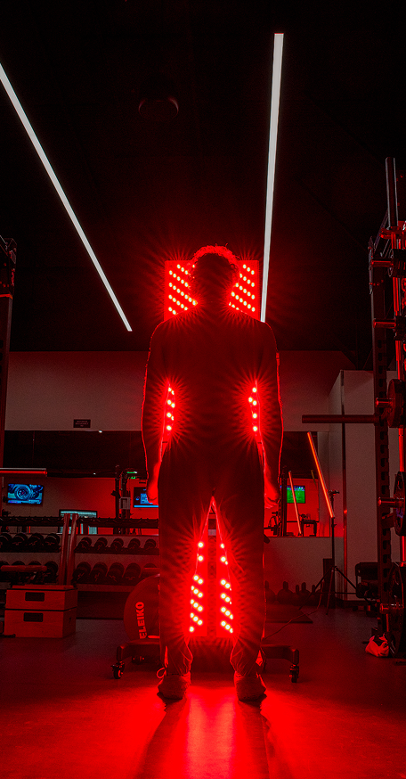 Athlete silhouette in front of a full-body Kala red light therapy station.