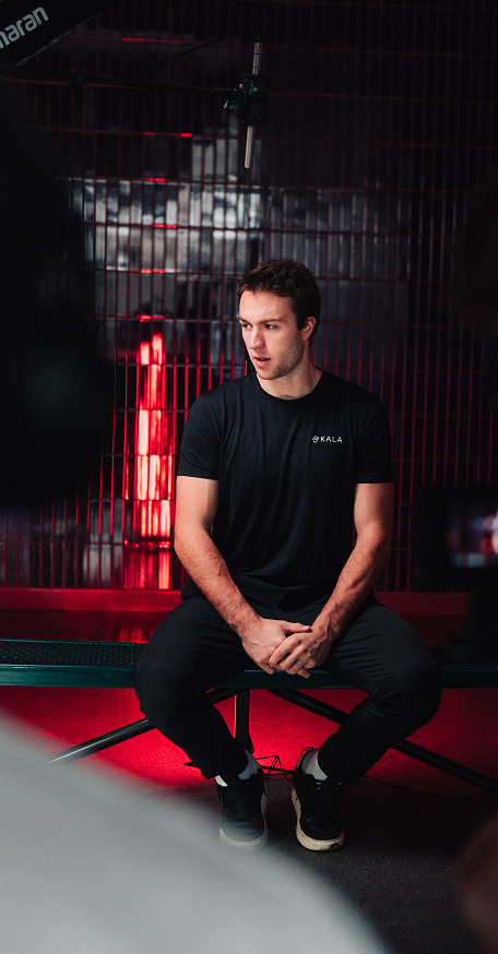 A man sitting in front of a studio backdrop with Kala red light therapy lighting.