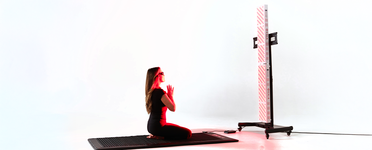 Person sitting on a mat with a kala red light, Full-body power. Maximum performance.